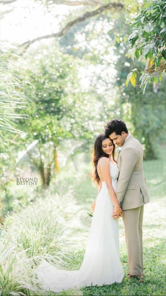 a bride and groom standing in the grass