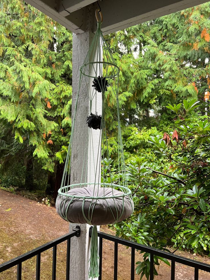 a hammock hanging from the side of a wooden pole in front of trees