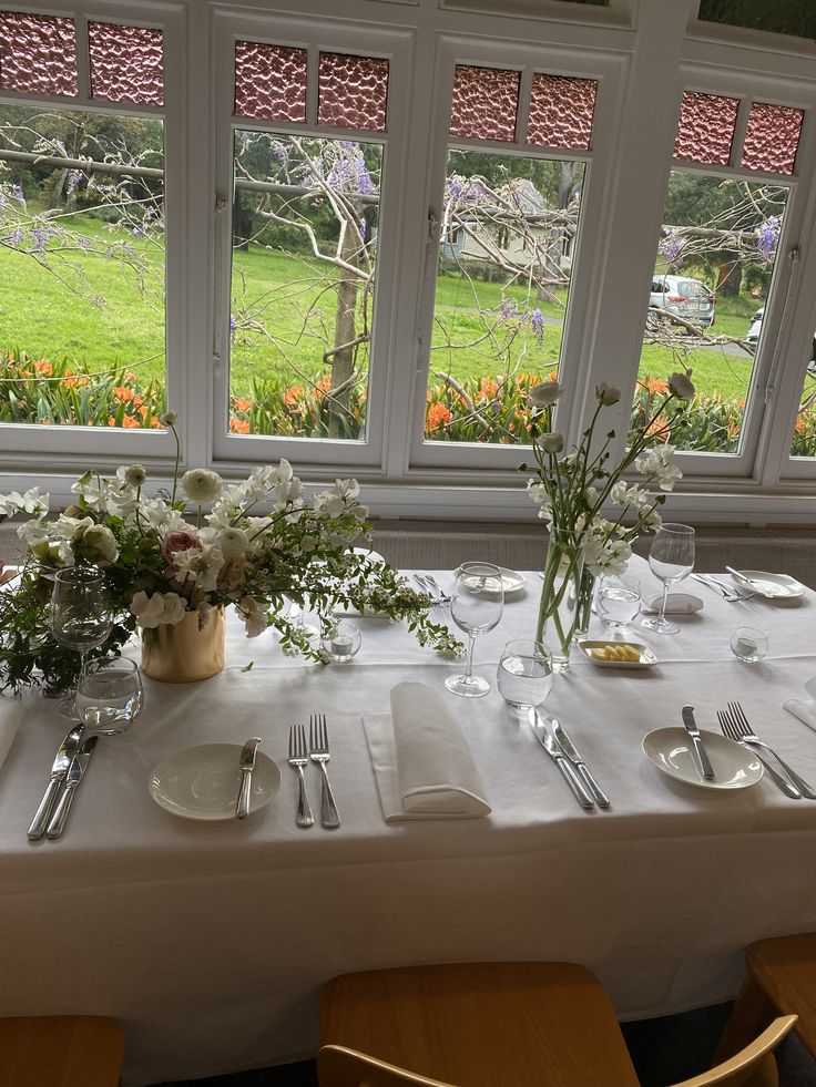 the table is set with flowers and silverware