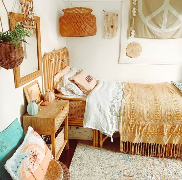 a bed room with a neatly made bed next to a mirror and hanging baskets on the wall