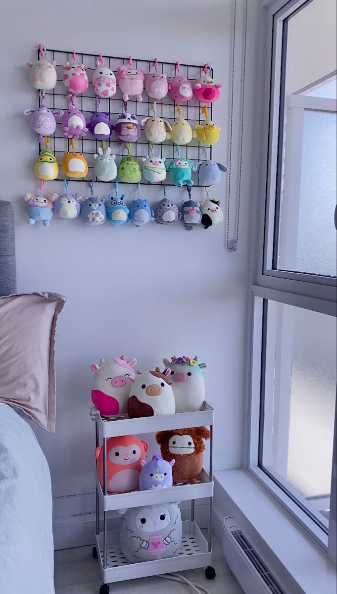 a shelf with stuffed animals on it next to a window