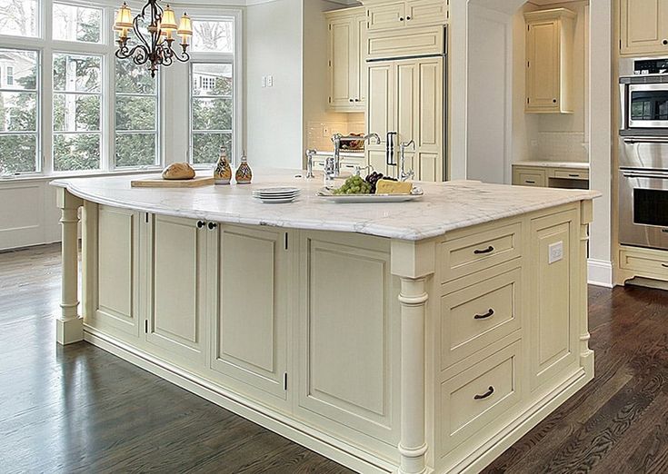 a large kitchen with white cabinets and an island in front of the stove top oven