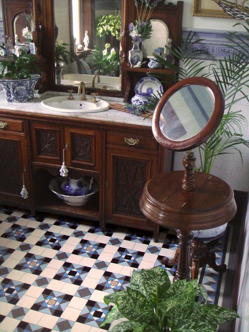 a bathroom with a sink, mirror and potted plants