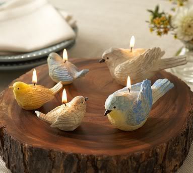 small candles in the shape of birds sitting on a tree stump