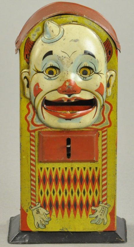 an old fashioned toy machine with a clown face on it's front and sides