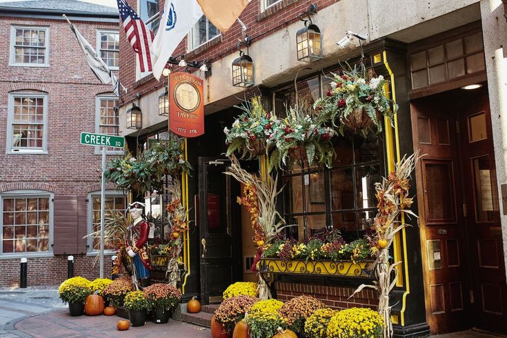 a store front decorated with pumpkins and flowers