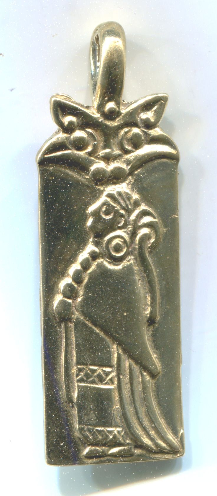 a gold pendant with an egyptian design on the front and back of it's face