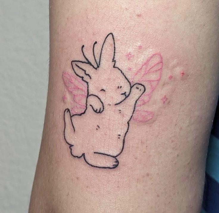 a small tattoo on the leg of a person with a bunny in it's lap