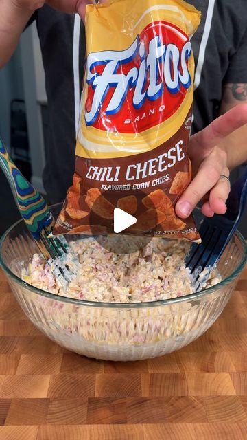 someone is mixing up some food in a glass bowl with a plastic fork and spoon