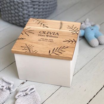 a wooden box sitting on top of a white floor next to two baby shoes and a stuffed animal