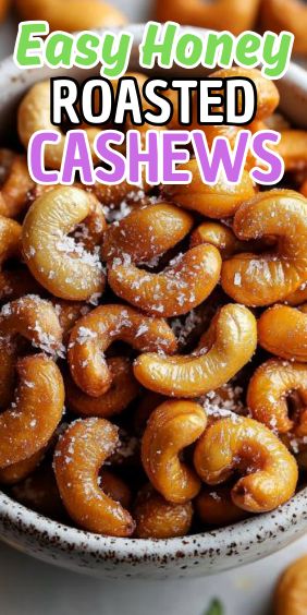 a bowl filled with cashews sitting on top of a white table next to other foods