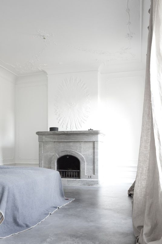 a bedroom with a fireplace and white walls