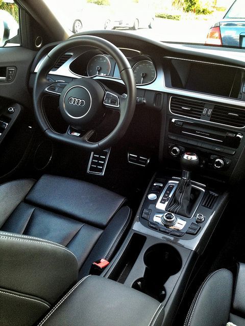 the interior of a car with black leather seats and steering wheel, dashboard controls and dash board