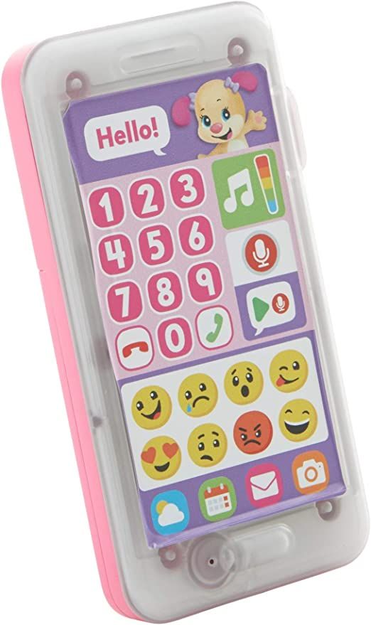 a pink and white cell phone with emoticions on the front, sitting in a plastic case