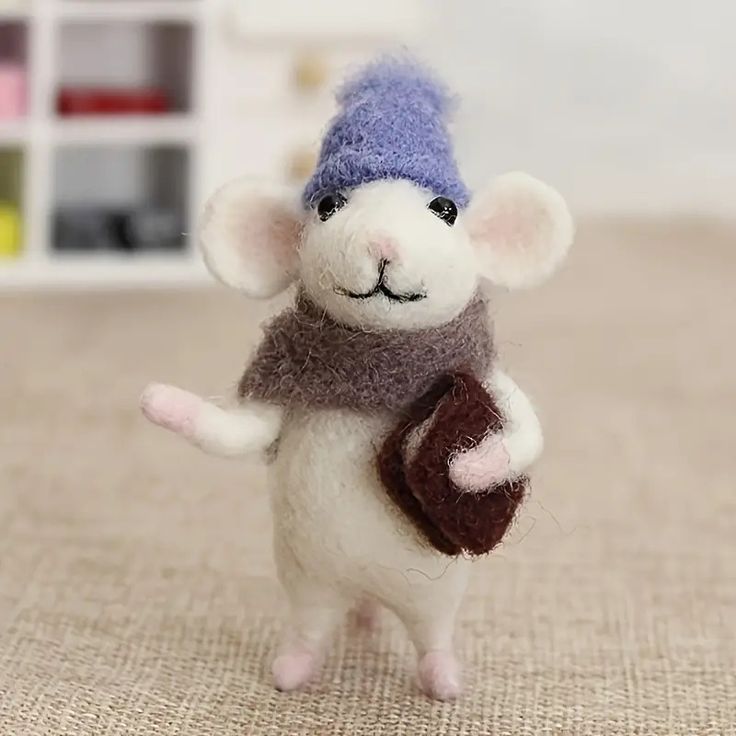 a small toy mouse wearing a knitted hat, scarf and mitten is standing on its hind legs