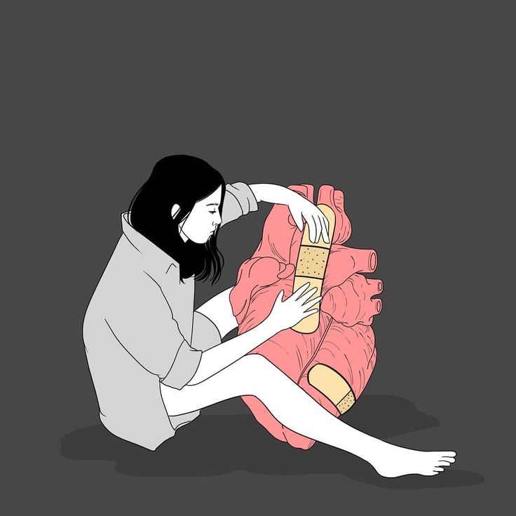 a woman sitting on the ground next to a human heart with bandages around her legs