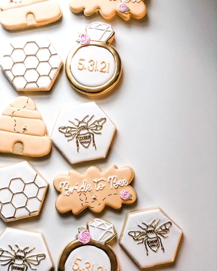 decorated cookies with honeycombs and bees are arranged on a white surface, including the words bee to bee