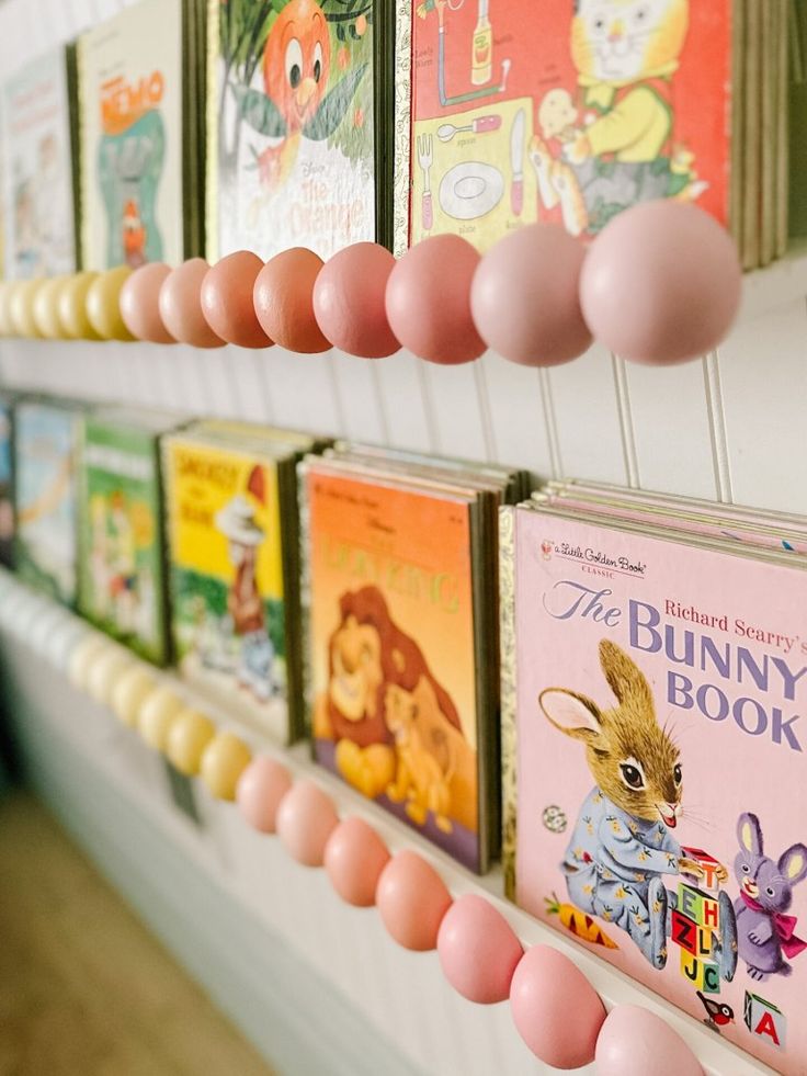 there are many books on the shelves with pink balloons hanging from it's sides