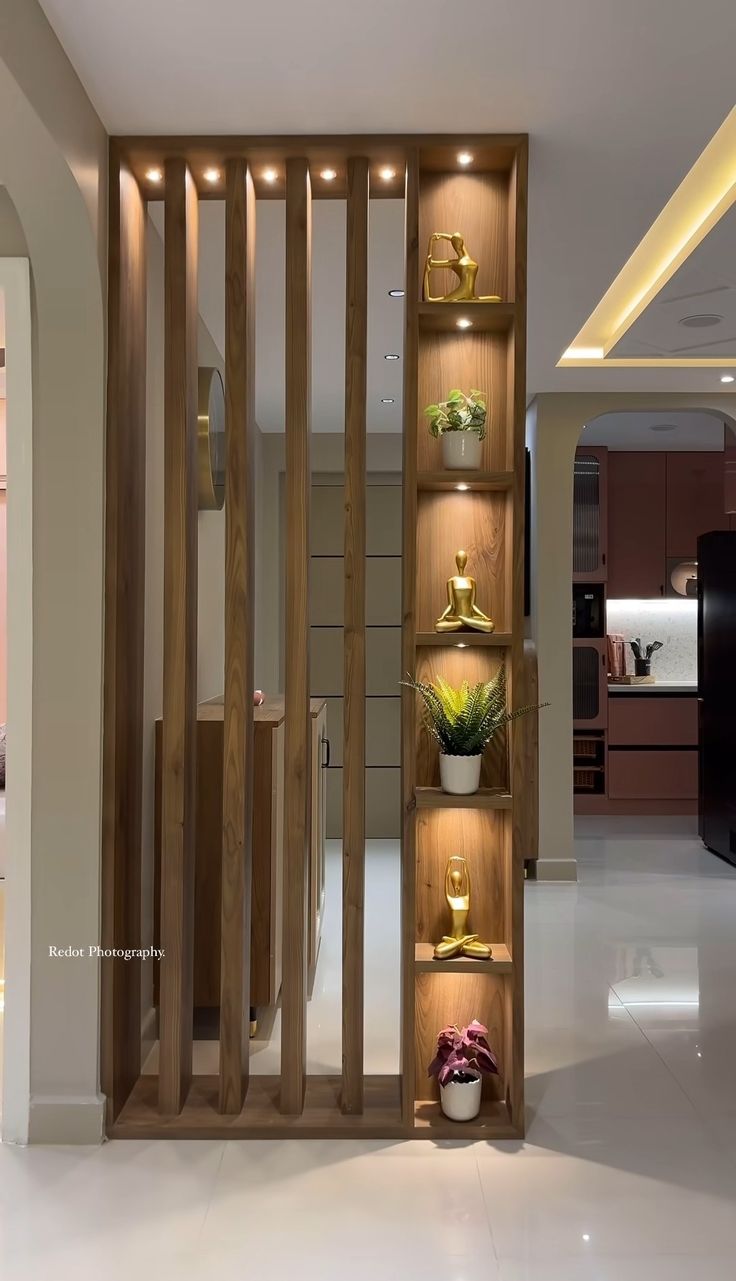 an open book shelf in the middle of a room filled with potted plants and vases