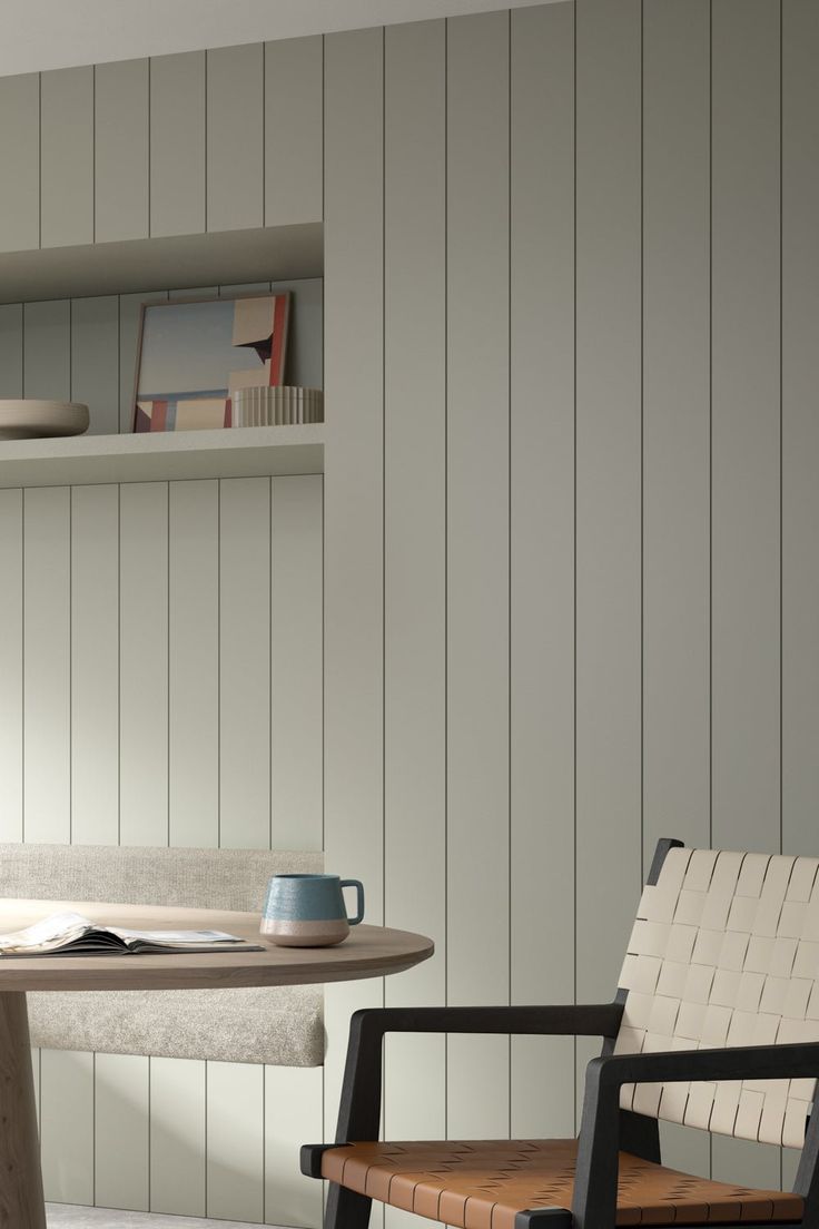 a wooden chair sitting next to a table in front of a book shelf with books on it