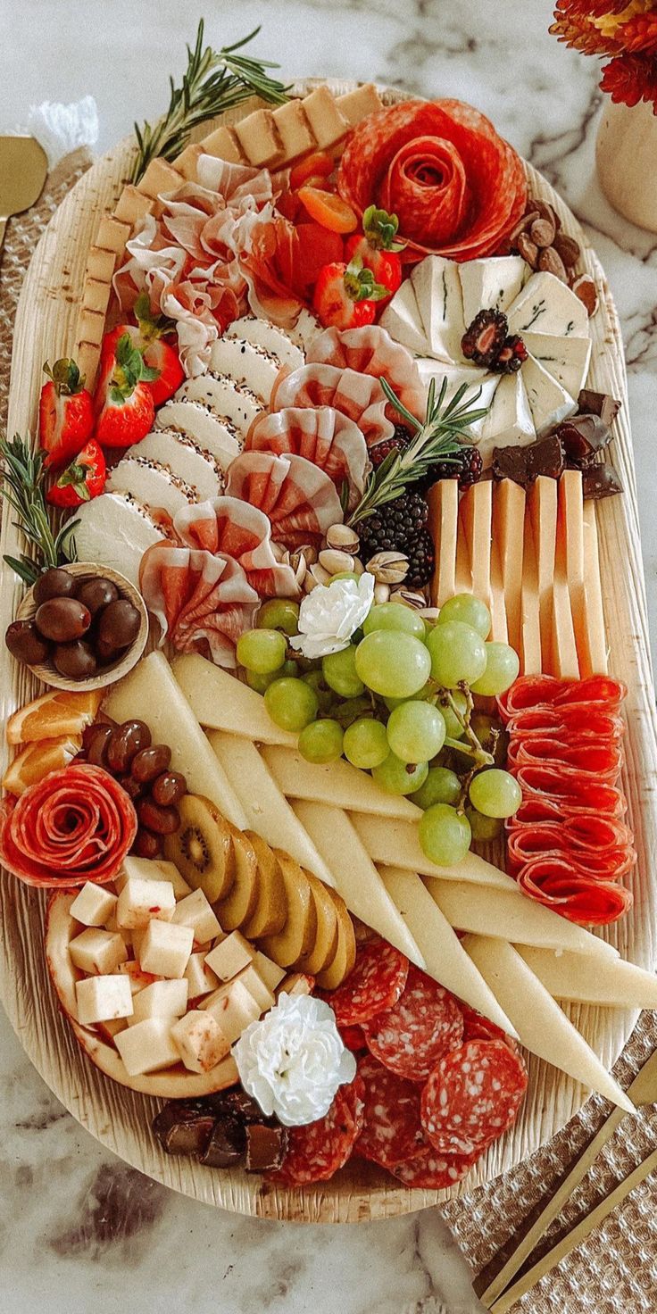 an assortment of cheeses and meats on a platter