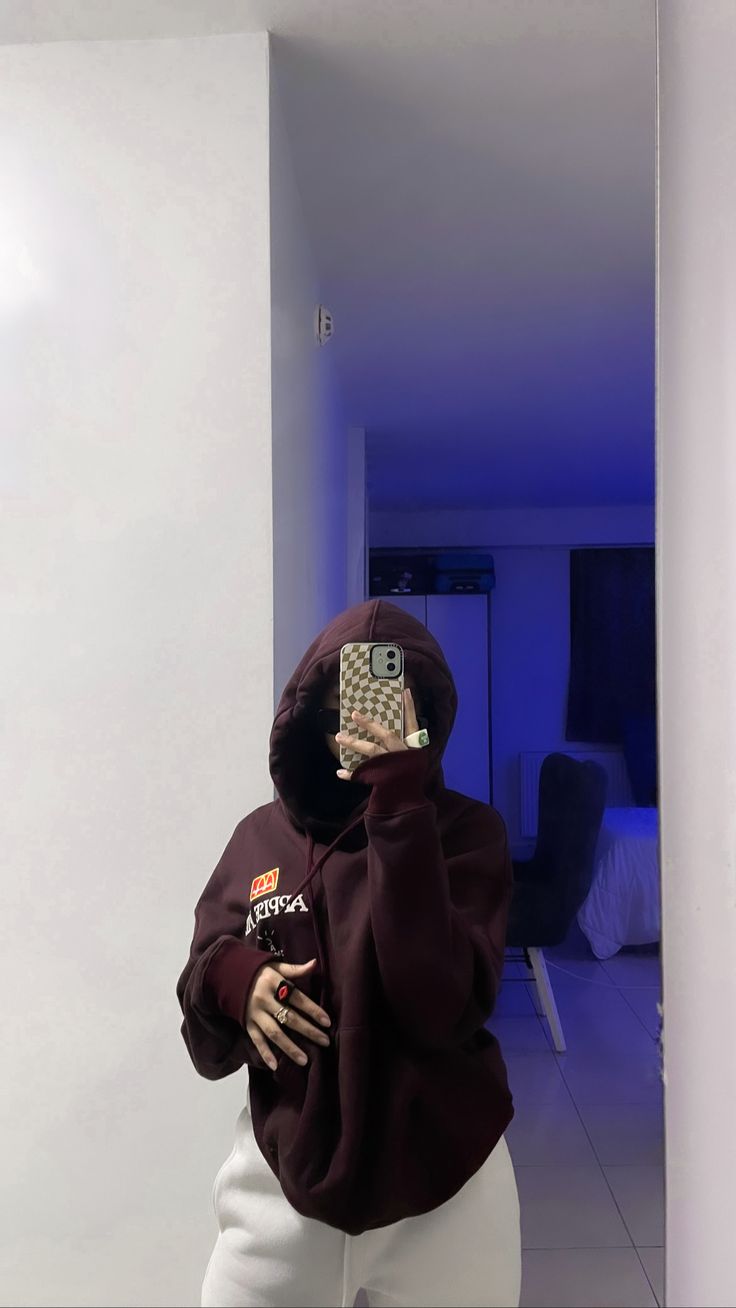 a person wearing a hoodie taking a selfie