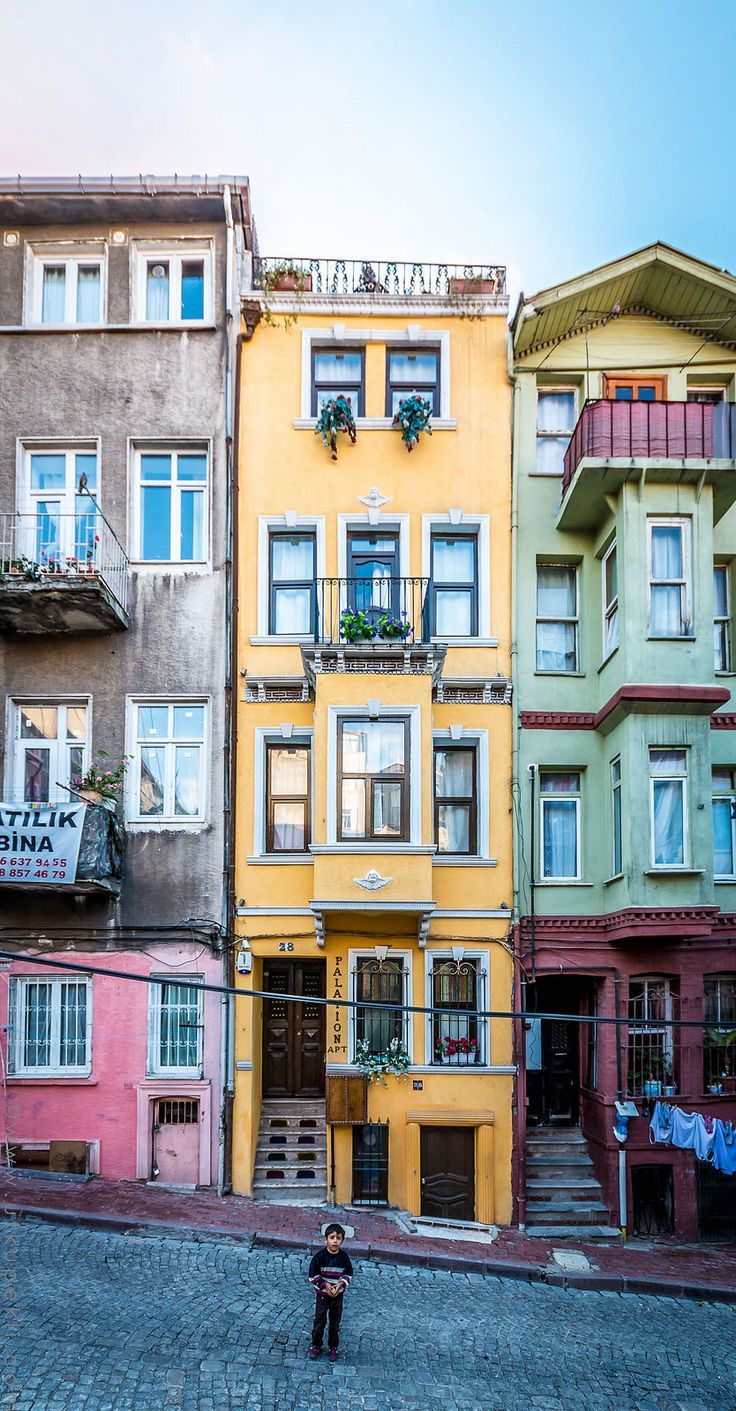 a person standing in front of some colorful buildings