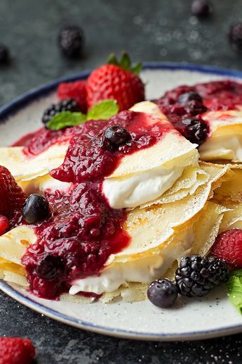 pancakes with berries and cream on a plate