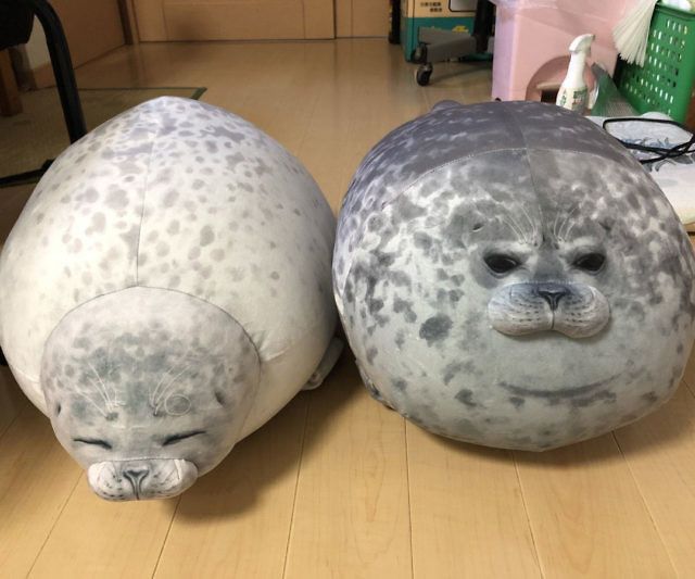 two stuffed animals sitting on top of a wooden floor