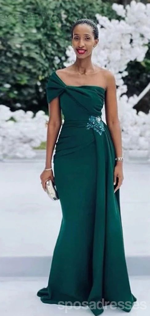 a woman in a long green dress posing for the camera with her hand on her hip