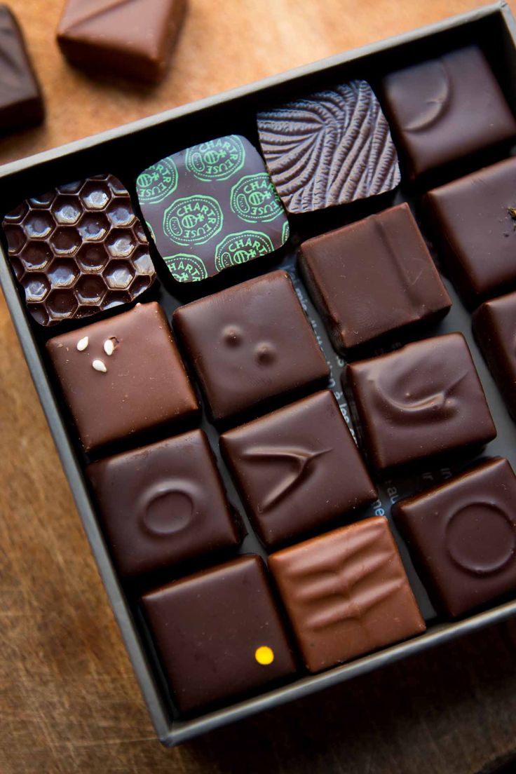 a box filled with chocolates sitting on top of a wooden table