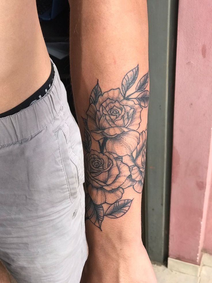 a person with a rose tattoo on their arm and leg is standing next to each other