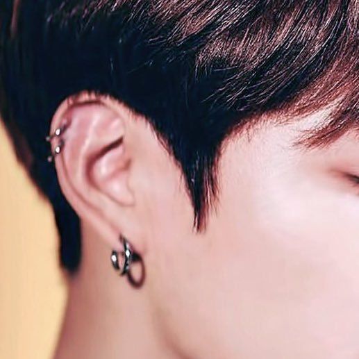 a close up of a person with ear piercings on their ears and behind the ear