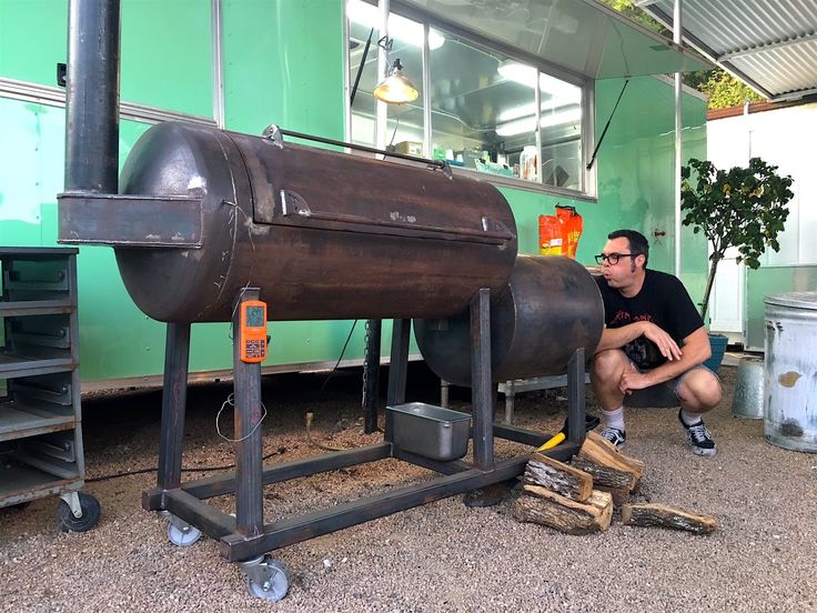 a man kneeling down next to a large metal object