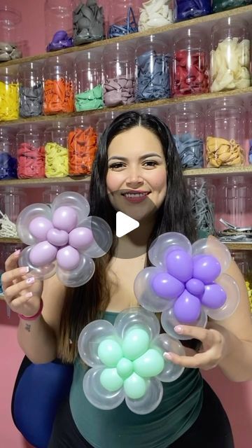 a woman is holding balloons in her hands