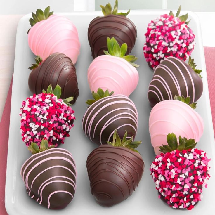 chocolate covered strawberries are arranged on a white plate with pink sprinkles