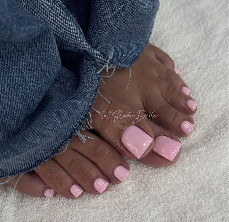 a woman's feet with pink manicures on top of her toenail