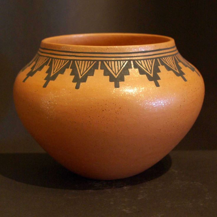 a brown vase with black designs on it