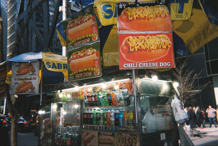 a hot dog stand in the middle of a busy street