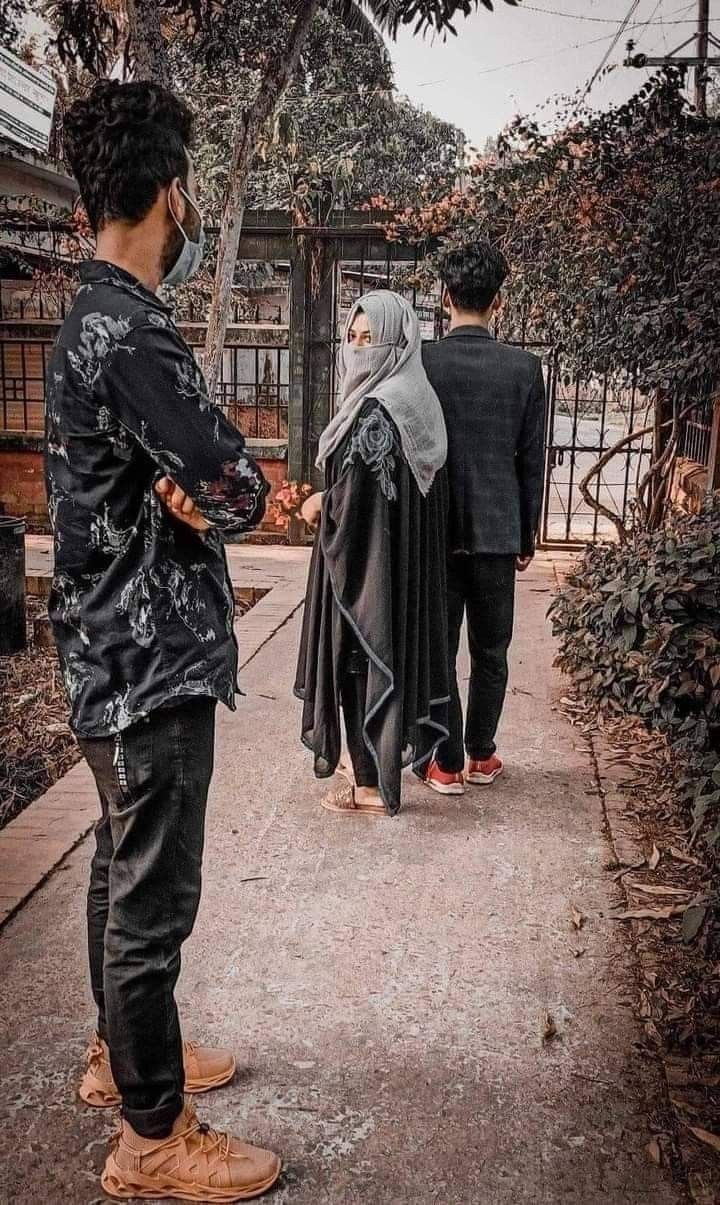 two men are walking down the street with one wearing a hijab and another in a suit