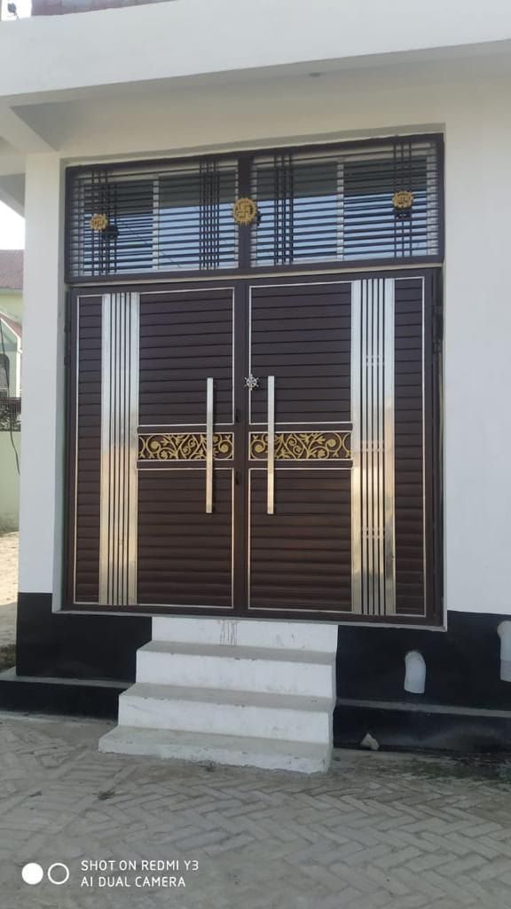 the front entrance to a house with wooden doors