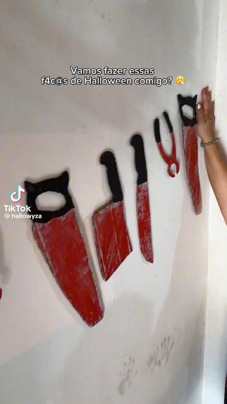 a woman standing next to a wall with scissors on it