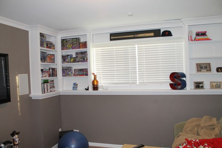 a living room filled with furniture and bookshelves next to a flat screen tv