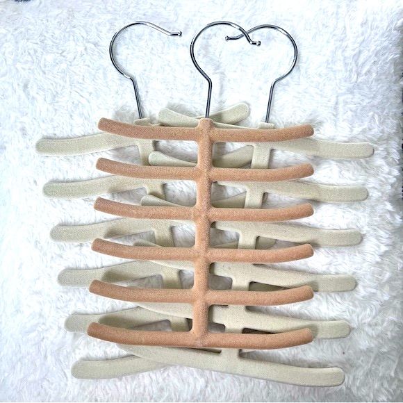 the back of a wooden hanger with multiple pairs of hooks attached to it on a white background