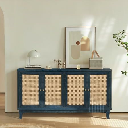 a blue cabinet with wicker doors in a white room next to a potted plant