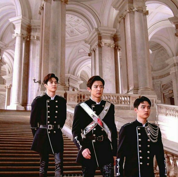 three men in uniform standing on the steps of an ornate building with columns and pillars