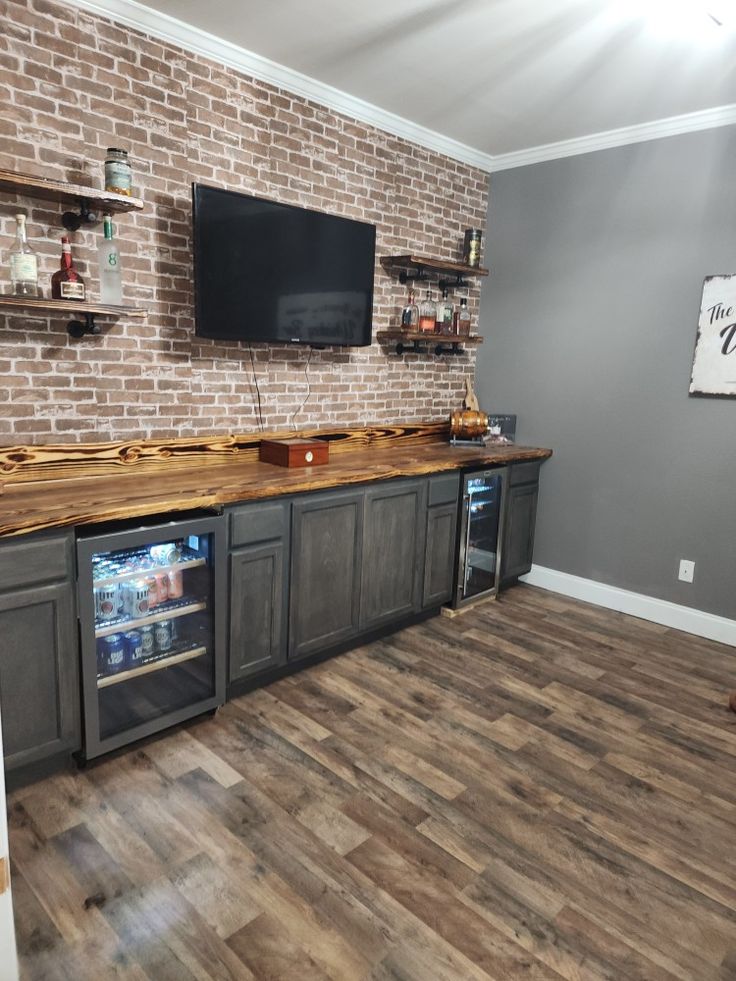 a kitchen with an entertainment center and brick wall