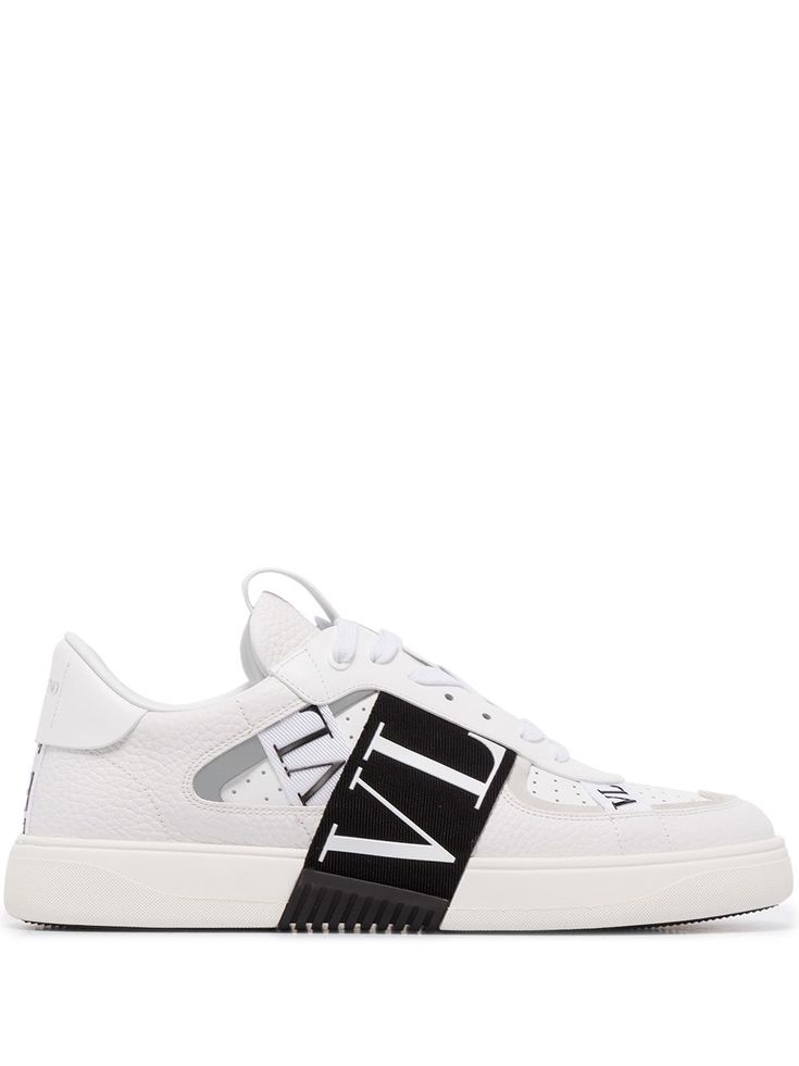 White/black leather VL7N low-top sneakers from VALENTINO GARAVANI featuring front lace-up fastening, panelled design, round toe, perforated design, logo patch at the tongue, branded heel counter, flat rubber sole and signature VL7N strap at the upper. Designer White Sneakers With Embossed Logo, Designer White Sneakers With Logo, Low-top Calf Leather Sneakers With Logo, White Calf Leather Sneakers With Logo Print, Luxury White High-top Sneakers With Logo, Designer White High-top Sneakers With Embossed Logo, Calf Leather High-top Sneakers With Perforations, Calf Leather Sneakers For Streetwear, Low-top Calf Leather Sneakers With Laces