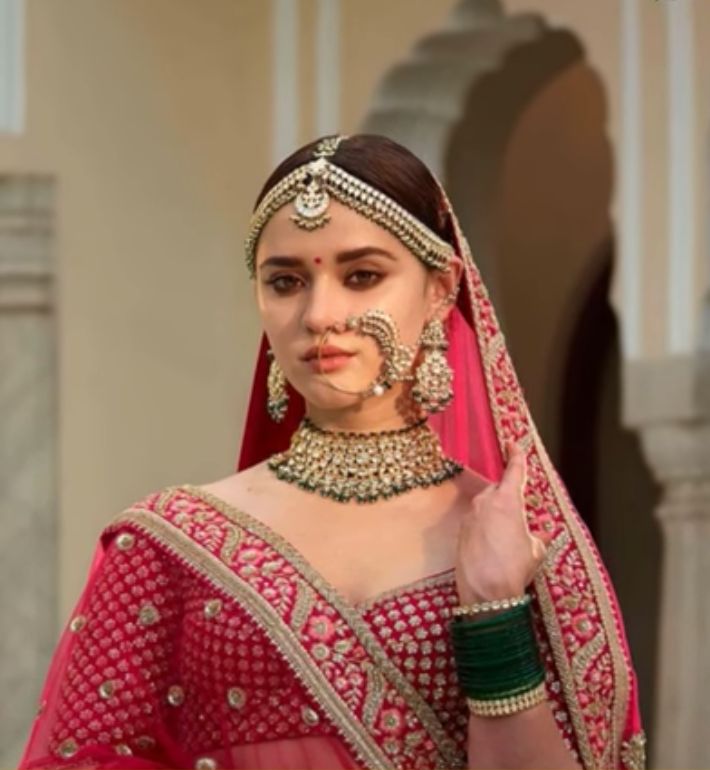 a woman in a red and gold bridal outfit