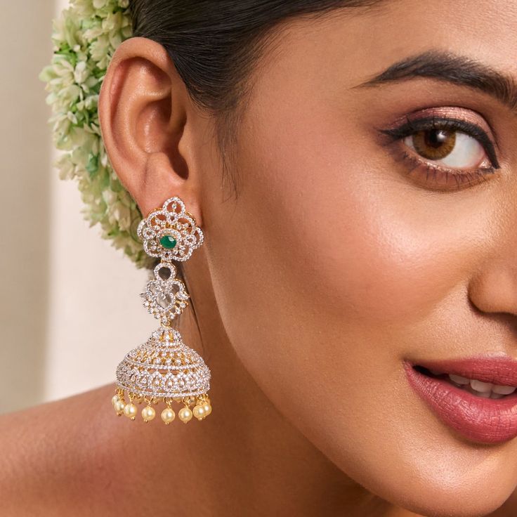 Description: Gorgeous and elegantly simple, these elegant CZ jhumka earrings add radiance to any outfit. Featuring an array of high-quality CZ stones set in 925 silvers in floral design, they shine beautifully. Style with a pastel-hued dress or an elegant silk saree to make the green center stone stand out. Product Information: Metal: 925 Silver with Gold & White Gold Plating Length: 7 cm Stones: High Grade CZ Stones Findings: Push back Hand-set Diamond Jhumkas, Cubic Zirconia Bridal Earrings For Festive Occasions, Fusion Style Danglers For Reception, Elegant Jhumkas With Intricate Design For Reception, Elegant American Diamond Jhumkas, American Diamond Danglers For Weddings, Elegant Diamond Chandbali Jhumkas, Elegant Diwali Jhumkas Drop Earrings, Hand Set Jhumkas For Wedding